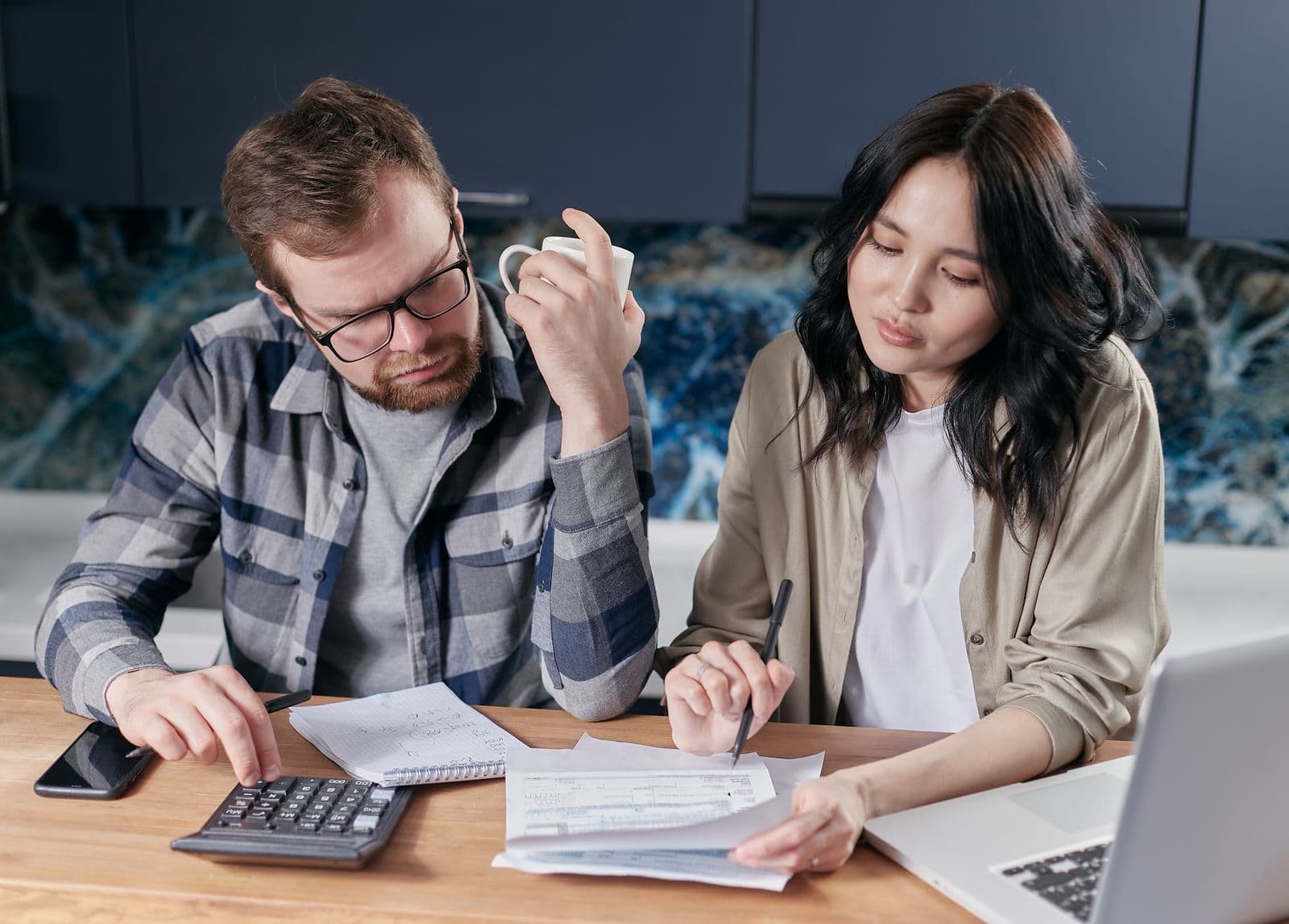 A couple comparing bills with a calculator